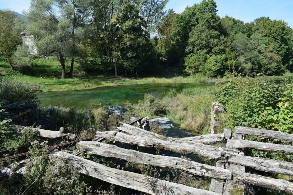 A wooden fence sitting next to a lush green field